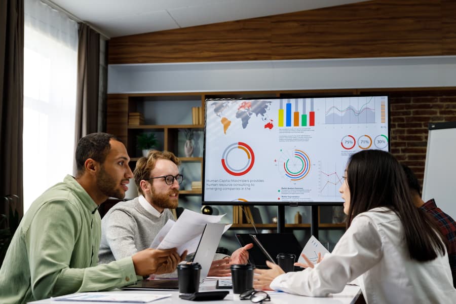 A group of young business people is meeting to discuss predictive analytics solutions A group of young business people is meeting to discuss predictive analytics solutions