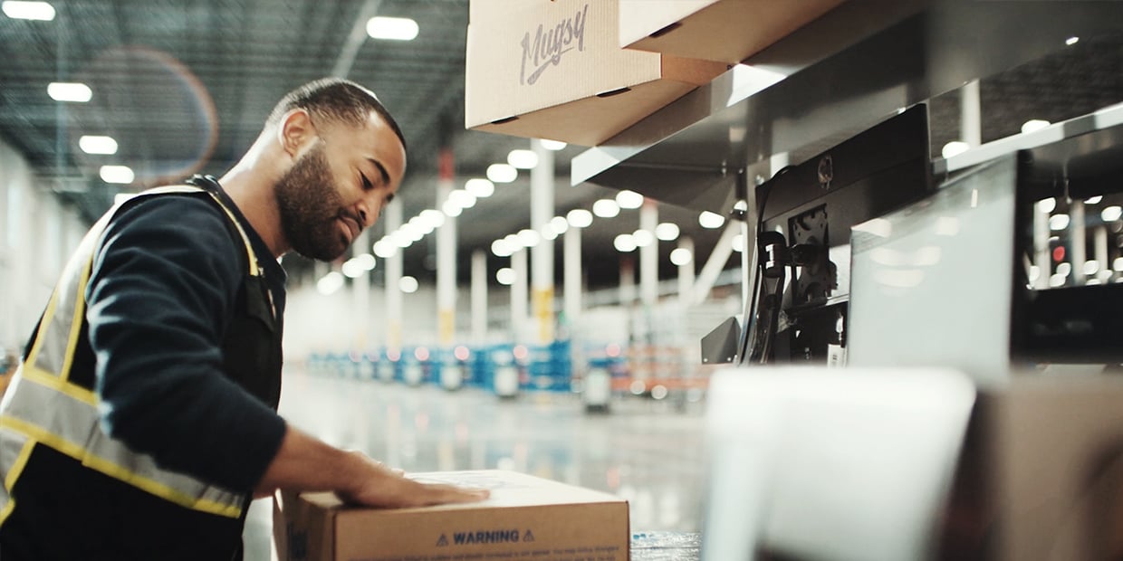 Ryder warehouse associate inspecting a package in an e-commerce fulfillment facility Ryder warehouse associate inspecting a package in an e-commerce fulfillment facility