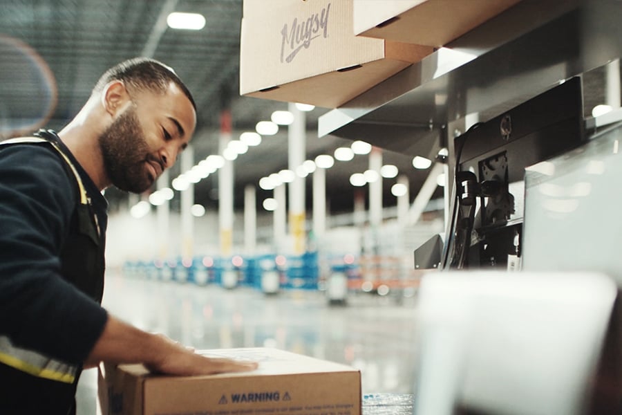 Ryder warehouse associate inspecting a package in an e-commerce fulfillment facility Ryder warehouse associate inspecting a package in an e-commerce fulfillment facility