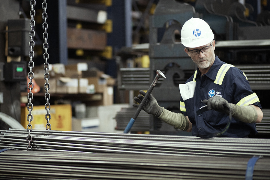 Engineer inspecting a bundle of steel tubing