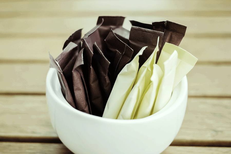 multiple black and white stick packages in a cup