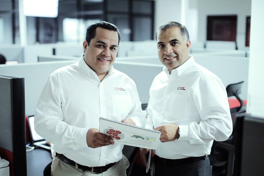 Diversidad e Inclusión two ryder employees side by side holding a journal with graphs
