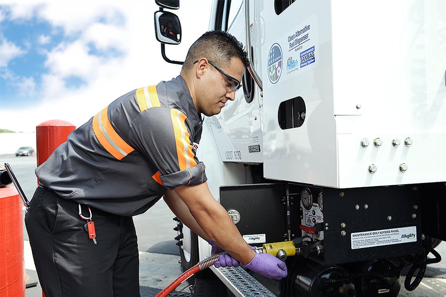 A Ryder technician filling up a semi truck with an alternative fuel A Ryder technician filling up a semi truck with an alternative fuel