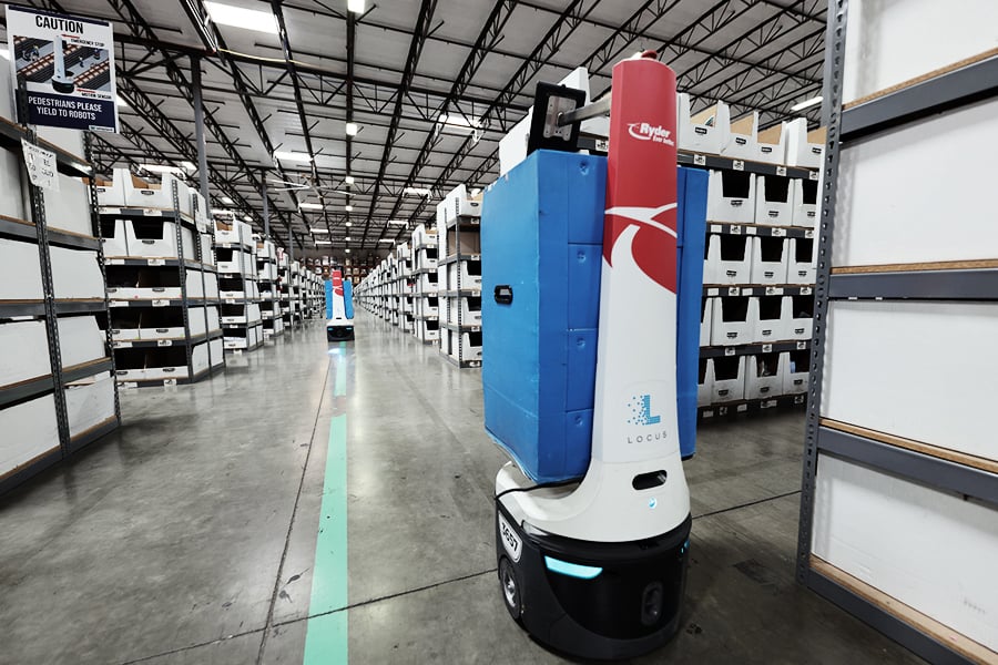 Autonomous mobile robots (AMRs) transporting goods across a warehouse floor Autonomous mobile robots (AMRs) transporting goods across a warehouse floor