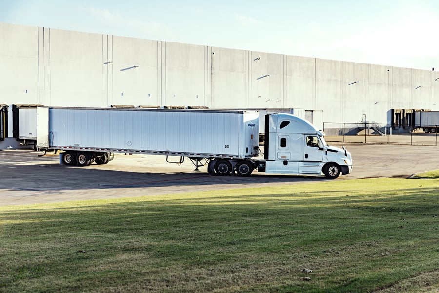 Semi-truck with trailer parked at a warehouse loading dock Semi-truck with trailer parked at a warehouse loading dock
