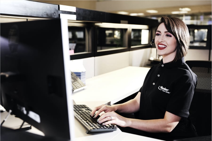 Ryder transportation management specialist smiling as she works on computer